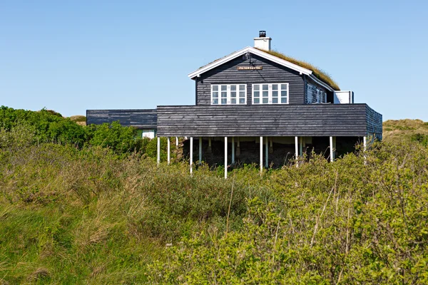 Maison danoise traditionnelle dans la dune de sable avec ciel bleu et herbe verte — Photo