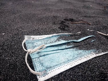 Çöpe atılmış kırık bir maskenin fotoğrafı.