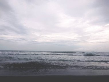 Dalgaların ve kumsaldaki kum manzaralarının fotoğrafları.