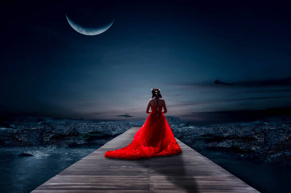 The bride stood on a wooden bridge on a beautiful half-moon night.