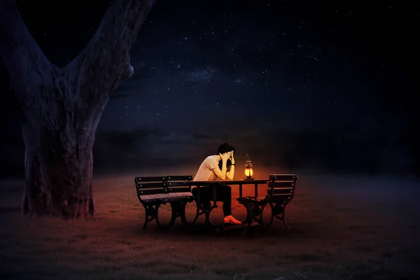 Yalnız bir gecede fenerlerle aydınlatılmış bir sandalyede oturan genç bir kadın..