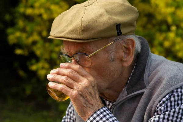 Yaşlı adam ile bir gri bir glas şarap içme sakal