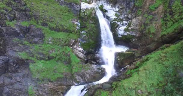 Belle cascade dans les Alpes, eau douce claire et lac vert .