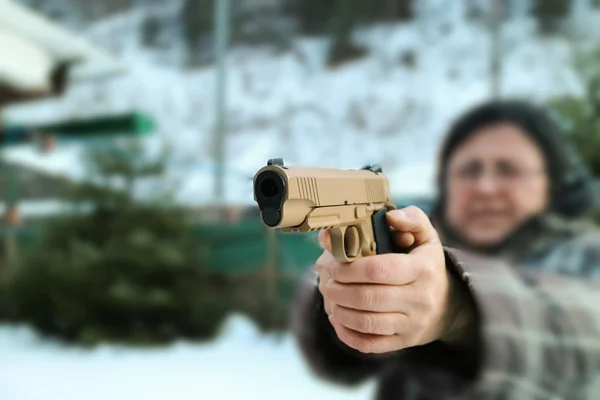 Woman shooting outdoor with a gun,  selective focus — Stock Photo, Image