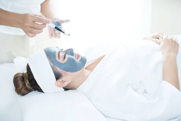 Facial Skin Care. An Asian woman is masking her face in a spa salon. Woman with cosmetic spa facial mask. Thailand.