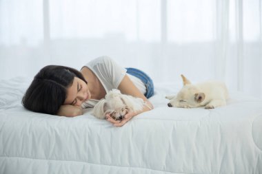 Bir Hokkaido inu köpeğiyle yatan Asyalı kadın..