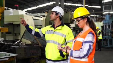 Endüstri mühendisleri ve bakım teknisyenleri. Mühendis tabletle robotu kontrol ediyor. İşi genç teknisyenler kontrol ediyor..