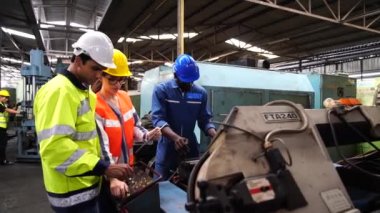 Mühendisler ve sanayi işçileri büyük makineler üzerinde çalışıyorlar.. 