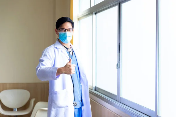 Healthcare and Medicine. Doctor posing with mask and show thump up.