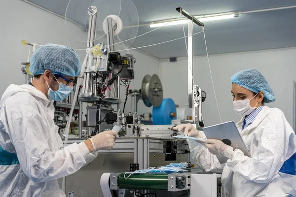 Maske Fabrikasındaki Çalışanlar Işçiler Makinelerin Çalışmasını Izliyorlar Yolda Bir Maske — Stok fotoğraf