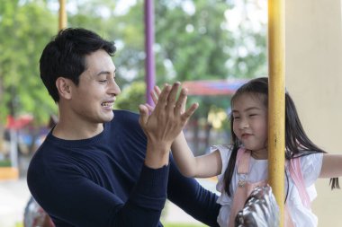 Lunaparktaki aile. Baba ve oğlu lunaparkta gülüyorlar. Atlıkarıncada oynayan çocuklu babamız..