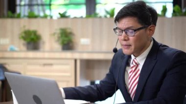 Genç çağrı merkezi müşteri sorularını cevaplamaya çalışıyor. Ofiste çalışan genç erkek müşteri destek yöneticisi.