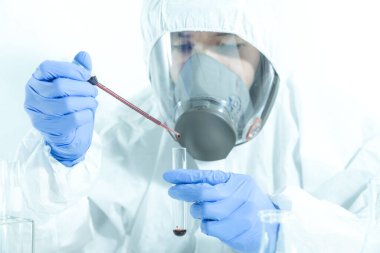 Doktor ya da bilim adamı kandaki virüs ya da bakteriyi inceliyor.