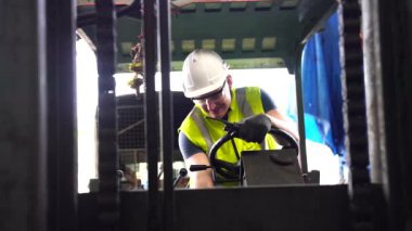 Forklift kullanan ustabaşı sektörde kontrol yapıyor. Endüstriyel fabrikada çalışan işçi ve forklift sürücüsü