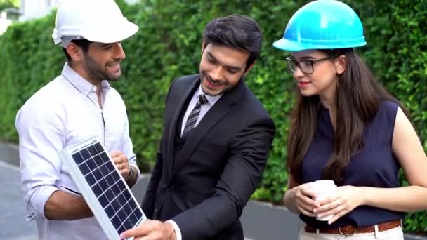 工程师介绍太阳能电池的工作为商人 工程师提出新的生态项目 围绕太阳能电池板的屋顶 手握太阳能电池板 — 图库视频影像