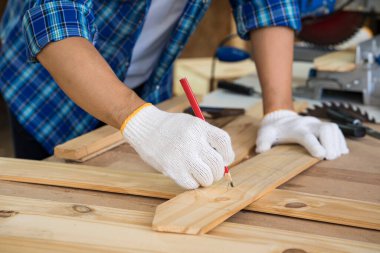 Marangoz ahşap fabrikasında ahşap kesme masası üzerinde çalışıyor. Ahşap işçiliği veya Profesyonel İnşaatçı Tamir Atölyesi.