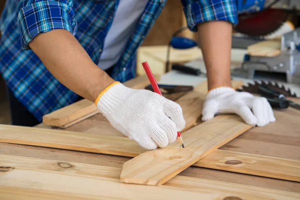 Marangoz ahşap fabrikasında ahşap kesme masası üzerinde çalışıyor. Ahşap işçiliği veya Profesyonel İnşaatçı Tamir Atölyesi.