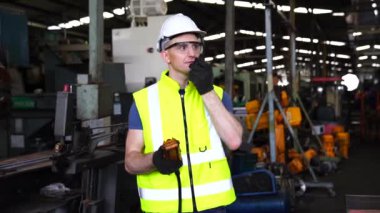 Sektörde çalışan bir mühendisin portresi. Foreman iletişim kurmak için telsizle çalışır. Profesyonel teknisyenler telsizle çalışır. Makineleri olan fabrikalarda.