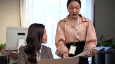 Çalışan yöneticiyle konuşuyor. Ofisteki genç iş kadınları kağıt işleriyle ilgili iş raporları hakkında konuşuyorlar.. 