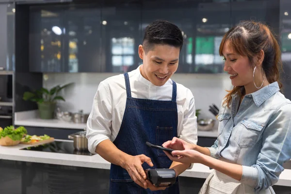 Mobile payment. Young women are paying for food by Contactless Payment.