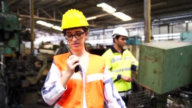Mühendis endüstrideki otomatik makineyi kontrol ediyor ve kontrol ediyor. Bakım teknisyenleri ve mühendisler fabrikadaki makineleri kontrol ediyor..