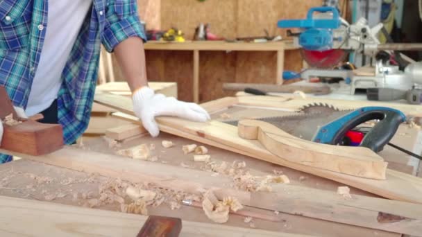 大工は飛行機を使っている 木工工場でプランナーを使用する男性大工 — ストック動画