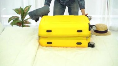 Seyahat için bavul hazırlayan bir adam. Genç adam tatil için bavul hazırlıyor. Seyahat hazırlığı da eğlenceli ve mutlu olaylardan biridir..
