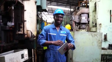 Mühendisler ve yetenekli teknisyenler makineleri koruyor. Profesyonel teknisyenler sanayi tesislerinde çalışmayı kontrol etmek için bir tablet tutuyorlar..