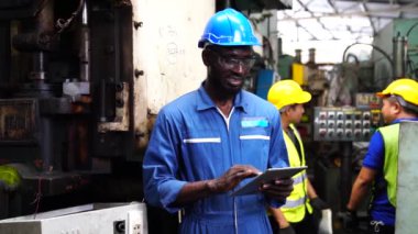 Mühendisler ve yetenekli teknisyenler makineleri koruyor. Profesyonel teknisyenler sanayi tesislerinde çalışmayı kontrol etmek için bir tablet tutuyorlar..