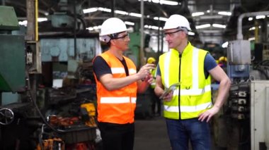 Teknisyenler endüstriyel makineler üzerinde çalışıyorlar. Fabrika atölyesinde makine ekipmanı kullanan bir grup işçi..