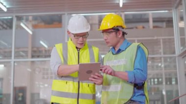 Mühendisler ve yetenekli teknisyenler makineleri koruyor. Profesyonel teknisyenler sanayi tesislerinde çalışmayı kontrol etmek için bir tablet tutuyorlar..