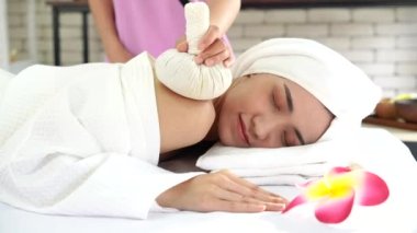 Kadın masaj terapisti kaplıcada masaj yapıyor. Kaplıca salonundaki genç kadın spa topuyla masaj yaptırıyor..