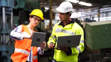 Bir ingiliz anahtarı ve tablet bilgisayarı makinenin önünde duran bir tamirci. Mühendisler ve yetenekli teknisyenler dört gözle bekliyor..