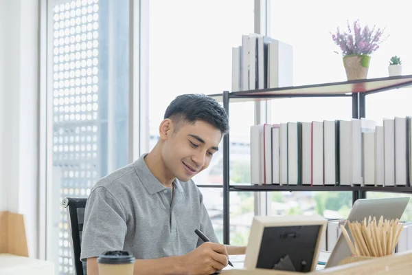 携帯電話を使用して働く男性 自宅のオフィスでコンピュータ机の上で働くアジア人男性 — ストック写真