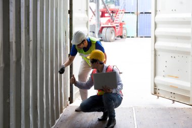Foreman ve ekibi stokları kontrol etmek için konteynırları açıyorlar. Limanda lojistik mühendisi kontrolü.