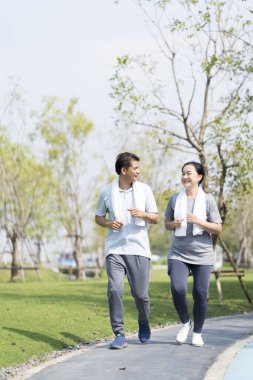 Bir çift bahçede koşarak egzersiz yapıyor. Egzersiz sonrası mutlu çift.