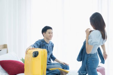 Bavul takmak için kıyafet seçen bir çift. Seyahat için kıyafet seçen ve bavul hazırlayan çift, tatile çıkmaya hazırlanıyor..