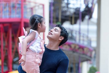 Baba ve kızı lunaparkta oynuyorlar. Lunaparkta aile atlıkarıncada. 