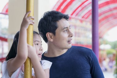 Baba ve kızı lunaparkta oynuyorlar.