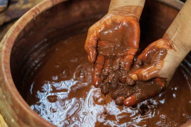 Tayland pamuğunun ustaları. Ağaç kabuğu ve volkanik çamur. Kavanoz kabuğu ve volkanik çamur Tayland 'ın bilgeliği olan pamuk ve ipeği doğal renklerle boyamak için kullanılır. 