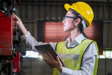 Asyalı kadınlar sanayi tesislerinde çalışıyor. Makinenin nasıl çalıştığını görmek için tableti elinizde tutun..