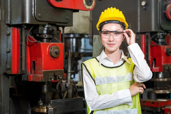 Manufacturing worker. Asian worker controlling the work. Portrait of cheerful worker wearing protective posing looking at camera and enjoying work.