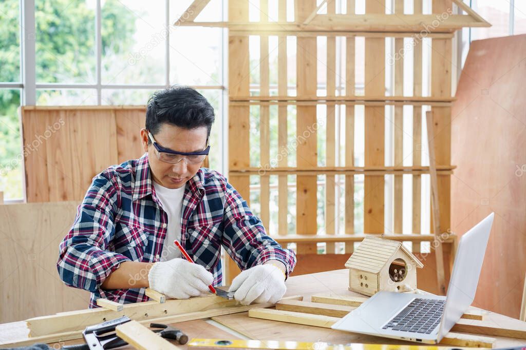 Carpenter making birdhouse. Carpenter or carpenter works in a workshop.