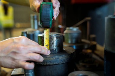 Çelik mezura kullanan bir el. Çelik mezura uzunluğu kullanan endüstriyel işçiler.