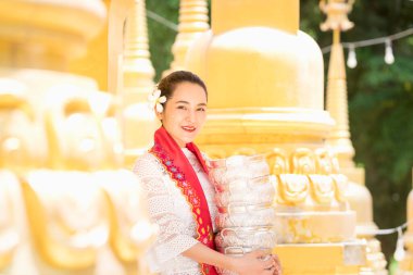 Birmanyalı dişiler tapınakta hak iddia edecekler. Myanmar 'daki güzel altın pagoda' da elinde geleneksel pirinç kasesi olan genç bir kadın..