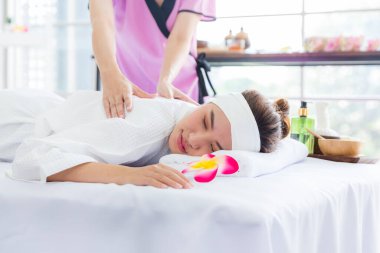 Young happy woman relaxing in spa salon. Young woman in spa salon lying on the massage desks.