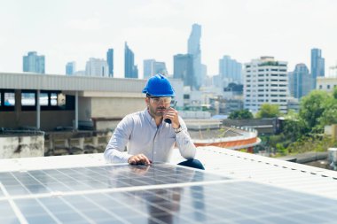 Foreman güneş panelinin çevresinde bir telsiz kullanıyor. Ofis binalarına elektrik sağlamak için kullanılır. 