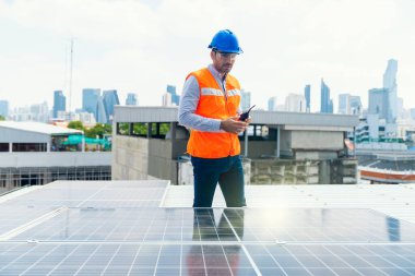 Foreman güneş panelinin çevresinde bir telsiz kullanıyor. Ustabaşı ve İşçi güneş enerjisi panelini koruyor.