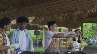 Öğretmen ay solucanlarını öğrencilere gösteriyor. Öğretmen bir grup öğrenciye bitki yetiştirmeyi öğretiyor..