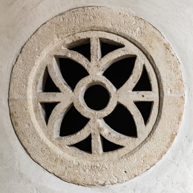 Simetrik bir tasarım içinde yuvarlak taş pencere.